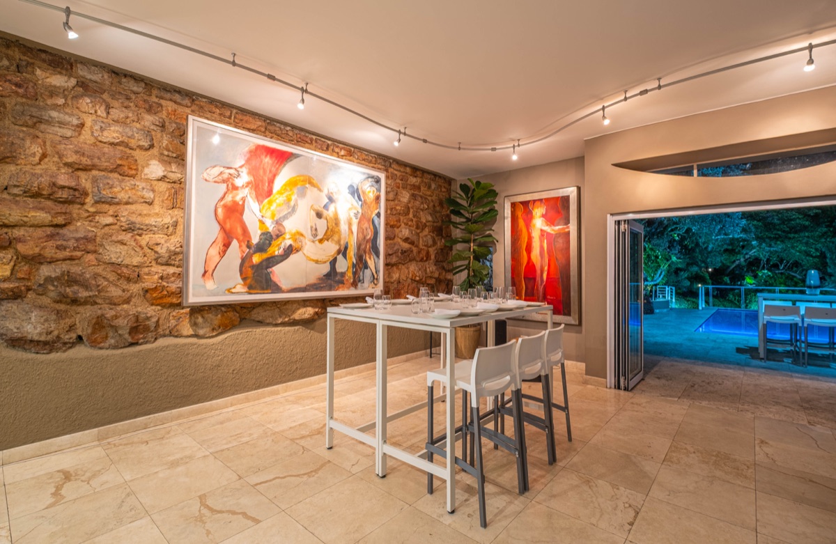 Cliffside art room with an exposed rock wall opening onto the illuminated pool deck