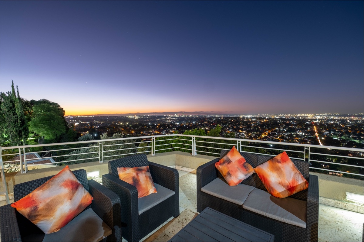 Cliffside lounge seating overlooking Johannesburg as the city lights come on