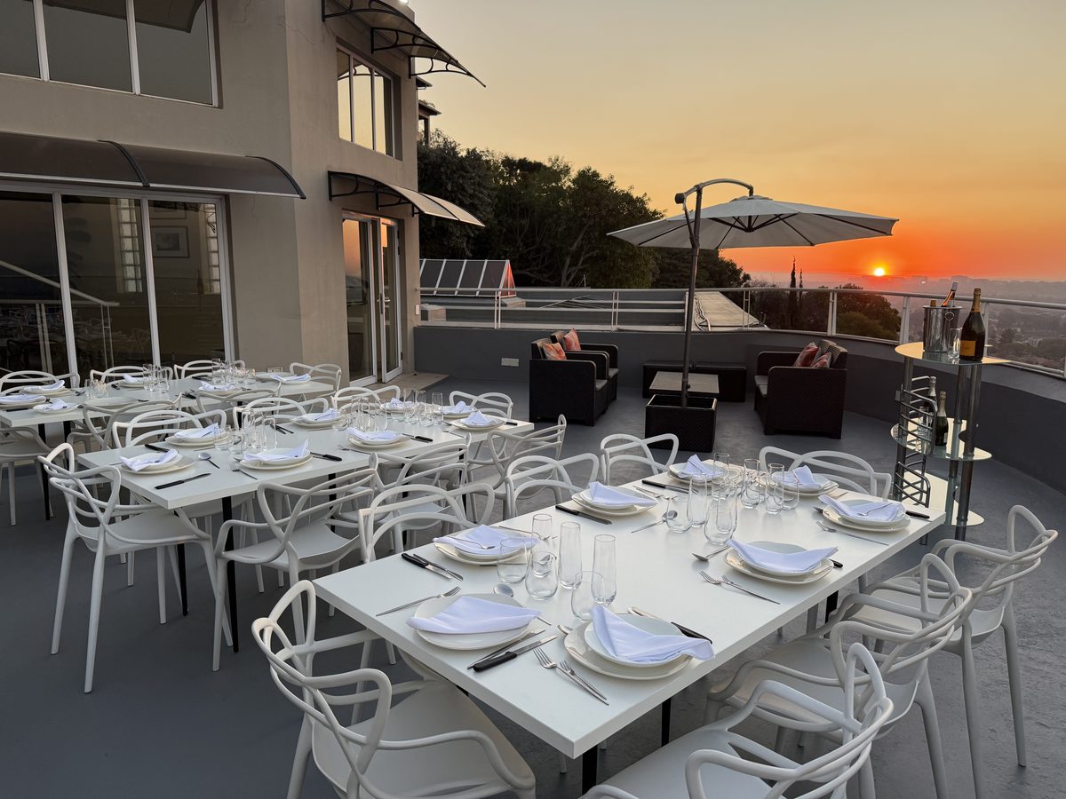 Horizons dining tables and lounge seating arranged beside the sunset city view