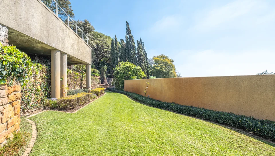 Open lawn beside the venue, framed by ivy-covered stonework and hedges